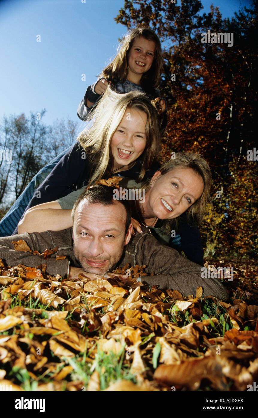 Familiy giacente su foglie di autunno Foto Stock