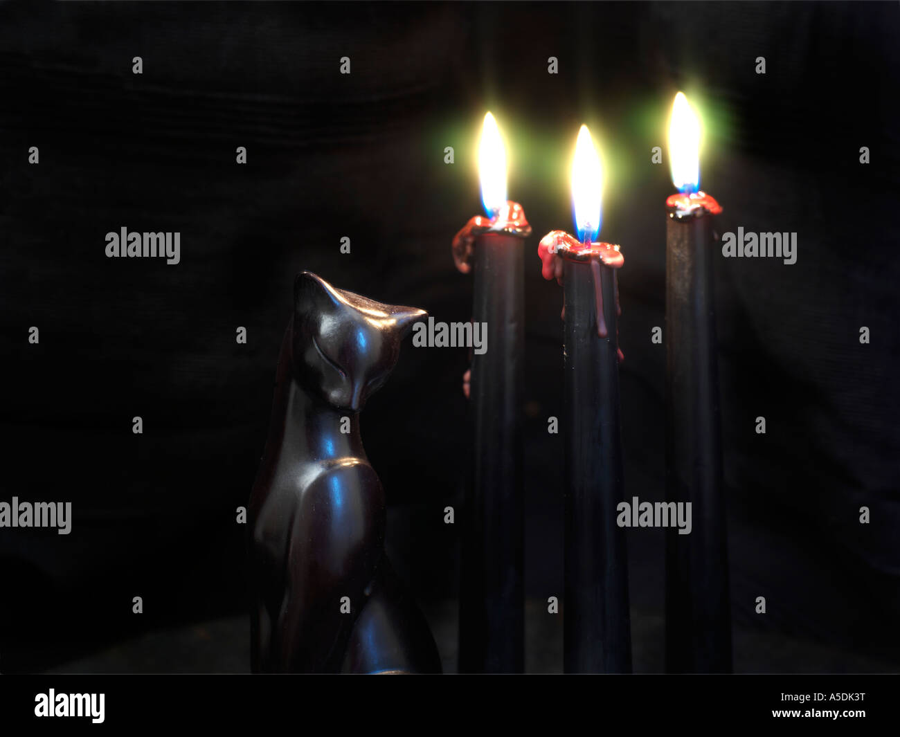 Tre candele nere con cera rossa gocciolamento verso il basso Foto Stock