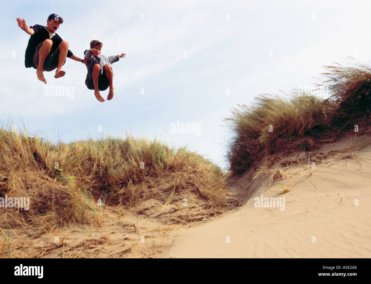 Due ragazzi adolescenti saltando al Beach Foto Stock