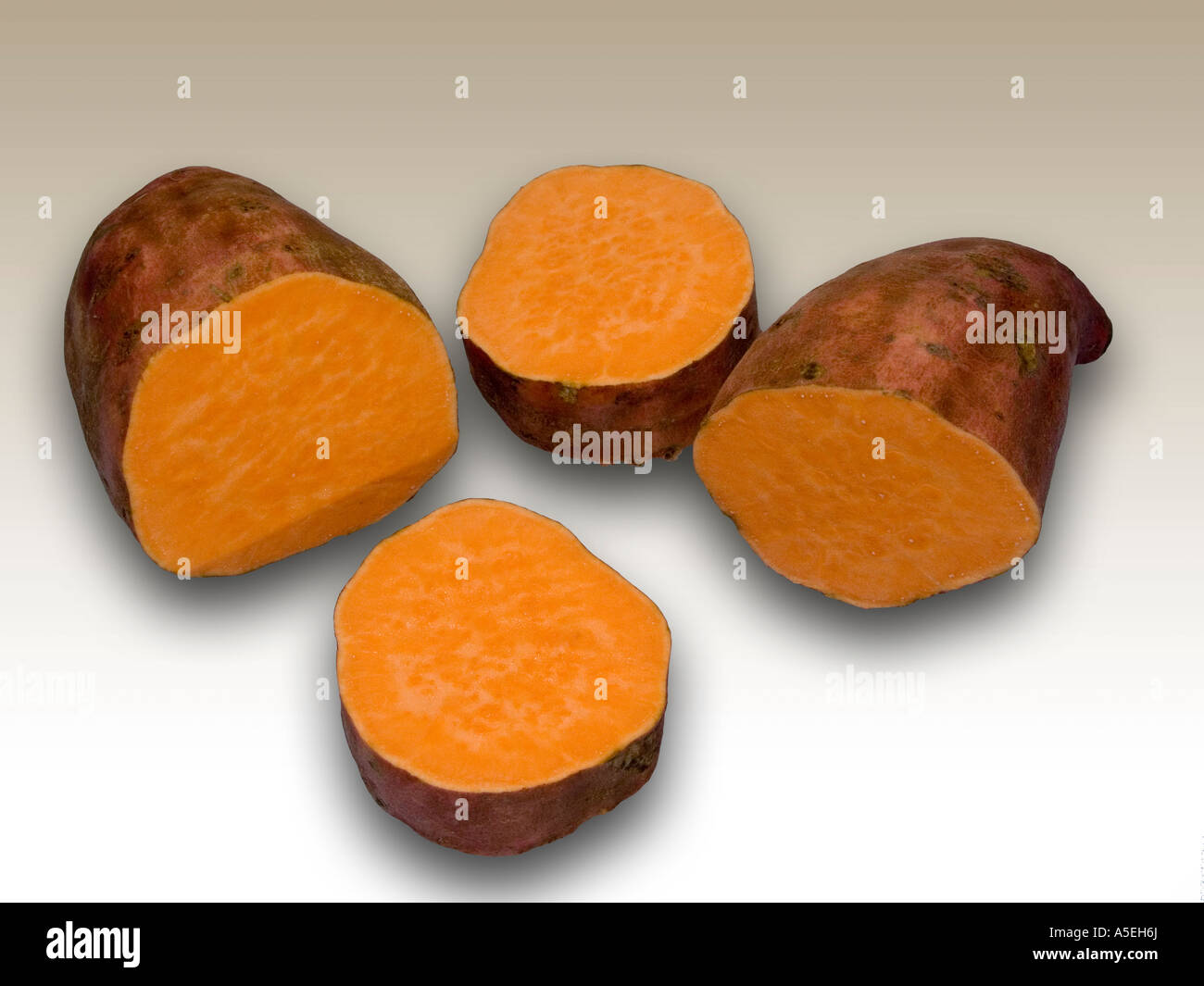 Ortaggi - orange patata dolce Beauregard e tagliare a fette in una luce del colore dello sfondo Foto Stock