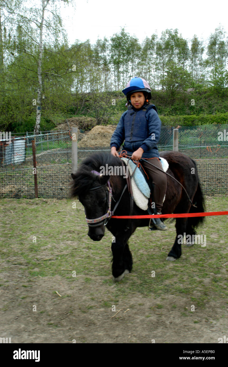 Ragazza nera con pony Shetland imparare a guidare Foto Stock