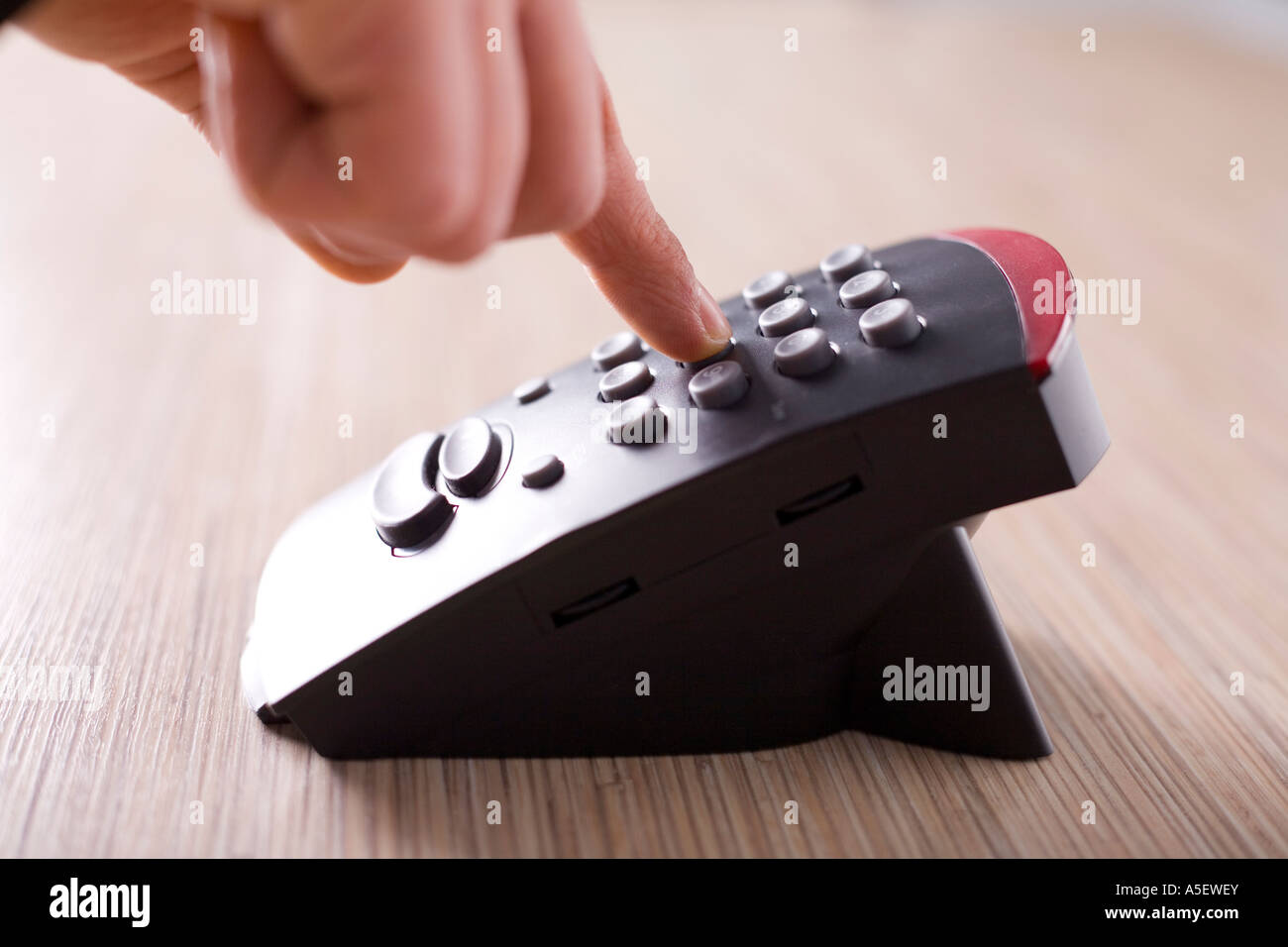 L uomo del dito sul quadrante di tasto del telefono è sulla scrivania concentrarsi sul dito Foto Stock