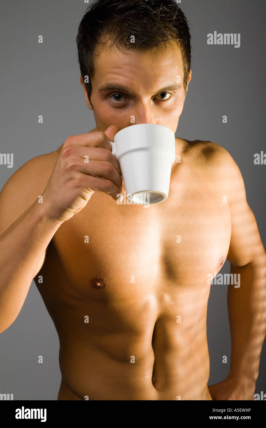 Giovane uomo in piedi nudi con la tazza di tè caffè accanto alla finestra  Foto stock - Alamy