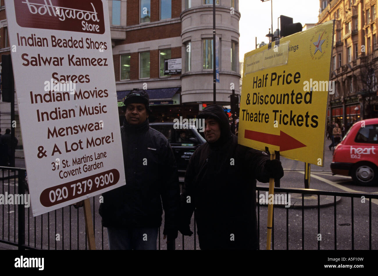 Due uomini che tengono le insegne pubblicitarie sulla strada a Londra Foto Stock
