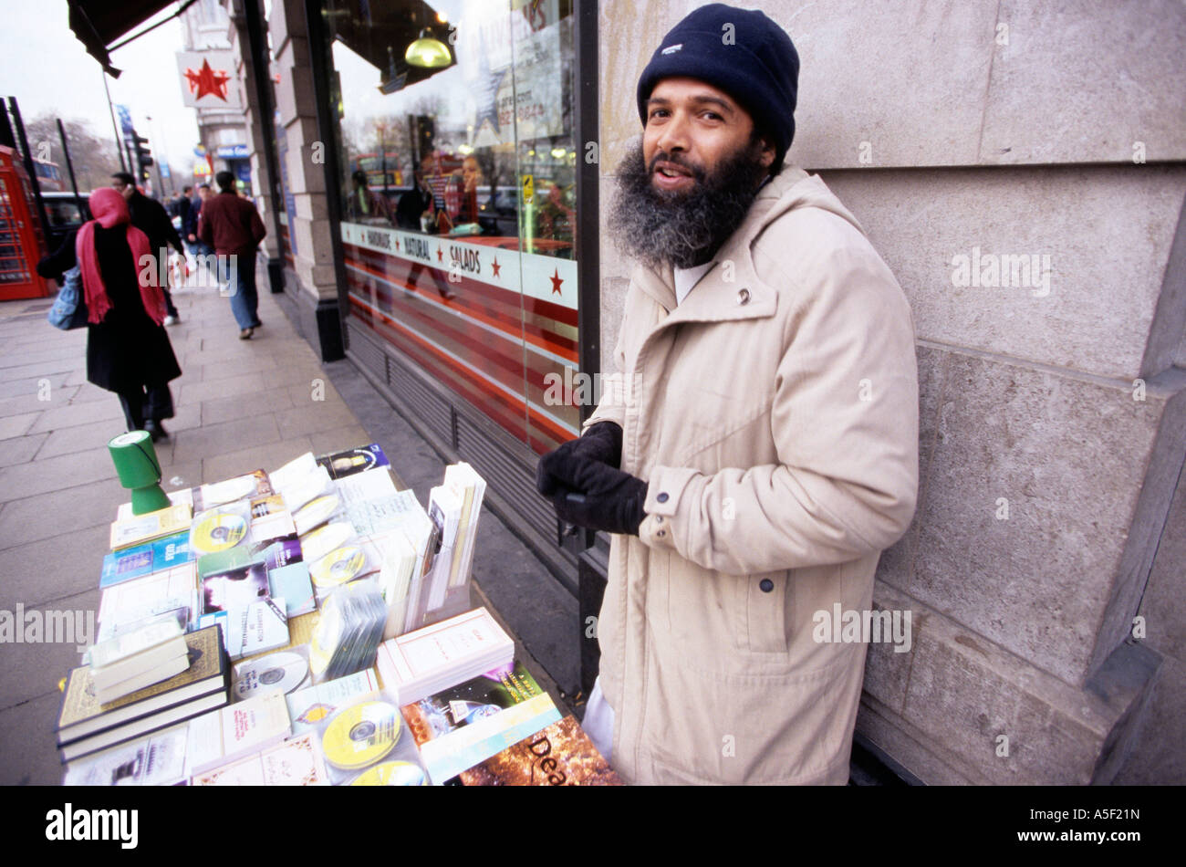 Un uomo vendita libri e cd su strada Foto Stock