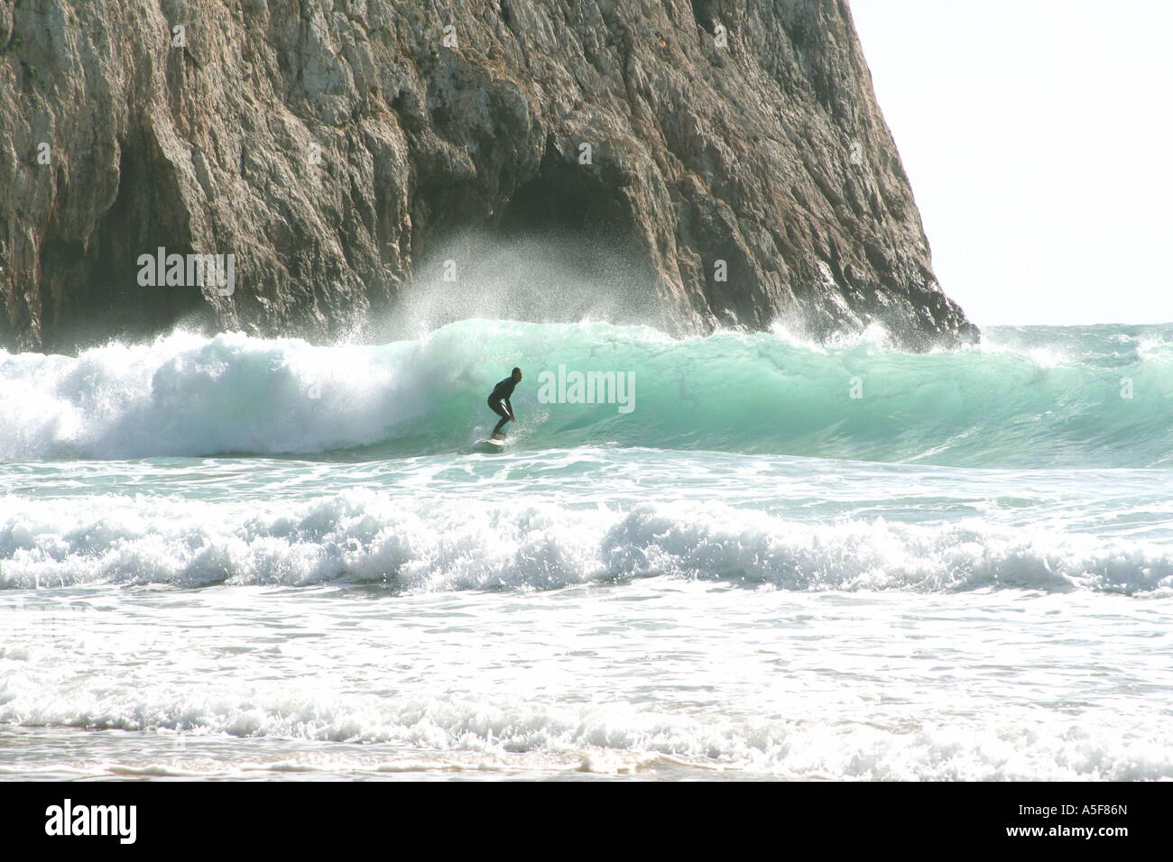 Surfer contro scogliere rocciose a Praia de Beliche beach Sagres la maggior parte Sud-Ovest point Europa Algarve Portogallo Foto Stock