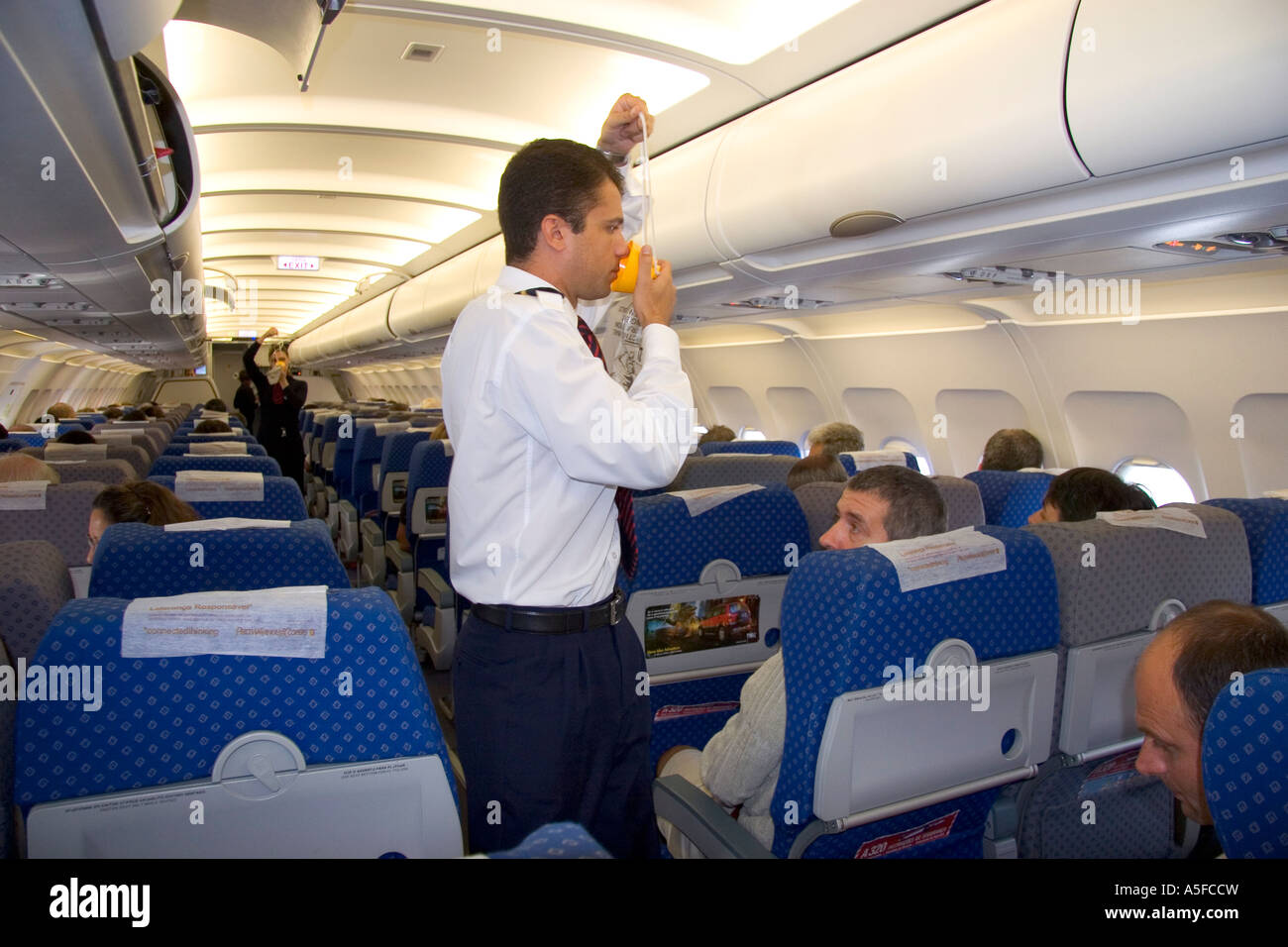 Un maschio di volo attendent dimostrando il corretto uso di una mascherina di ossigeno Foto Stock