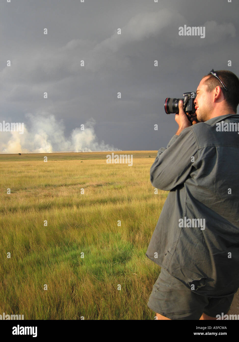 Masai Mara, Kenya, Africa, Guida Safari fotografie grassfire all'orizzonte Foto Stock