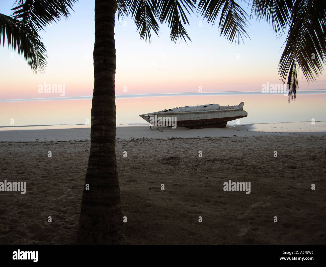 Una barca su una spiaggia del Madagascar presso sunrise con acqua liscia in Ifaty, nei pressi di Toliara ( Tulear ) Foto Stock