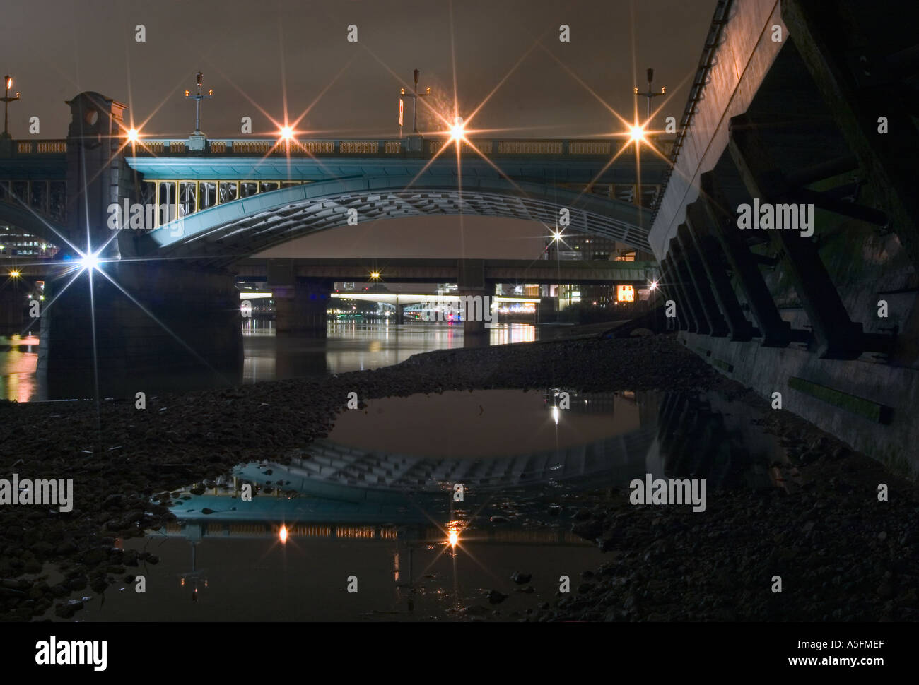 Southwark Bridge e riflessioni in foreshore di notte. Il Tamigi a Londra, Inghilterra Foto Stock