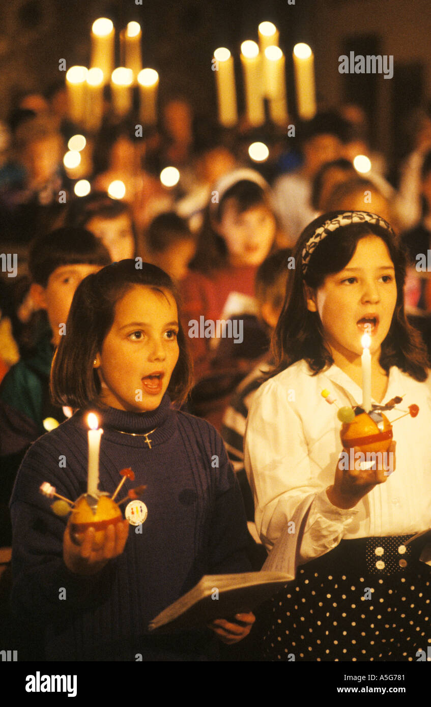 Teen schoolgirls Christingle Christmas Church carol service kids canto. Con le candele accese con Leighton Buzzard arancione anni '1990 HOMER SYKES del Regno Unito Foto Stock