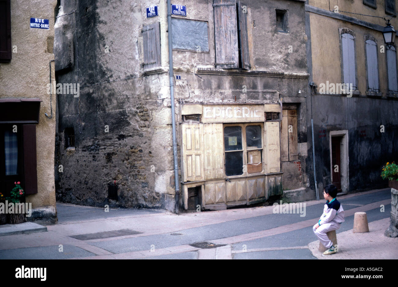Ragazzo in cortile quadrato Lozere Mende Francia meridionale con il vecchio chiuso locale e tradizionale negozio francese Foto Stock