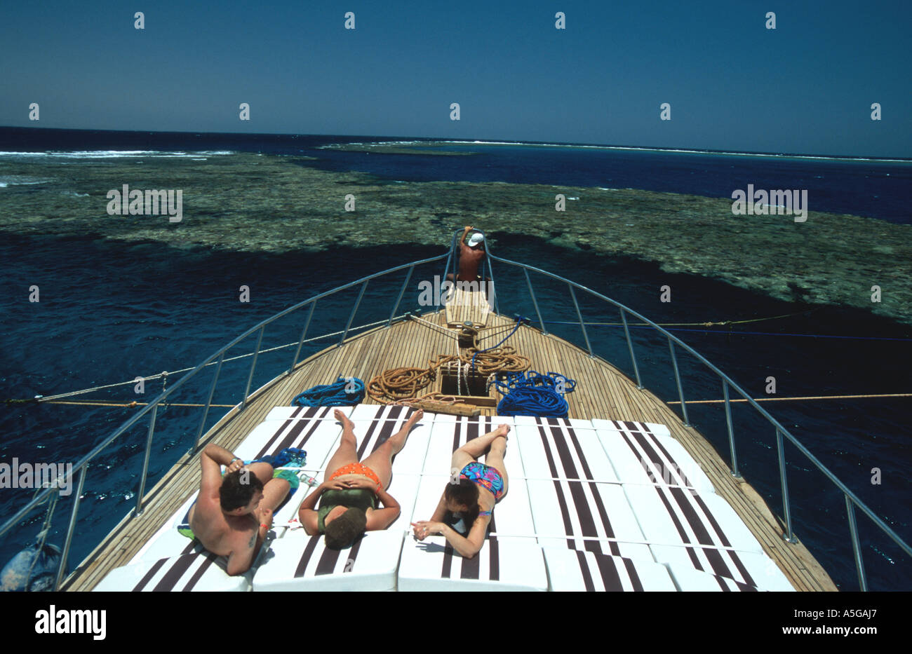 I turisti subacquei persone sole ponte anteriore sulla barca a off-shore reef immersioni a Marsa Alam sud del Mar Rosso in Egitto deep sou Foto Stock