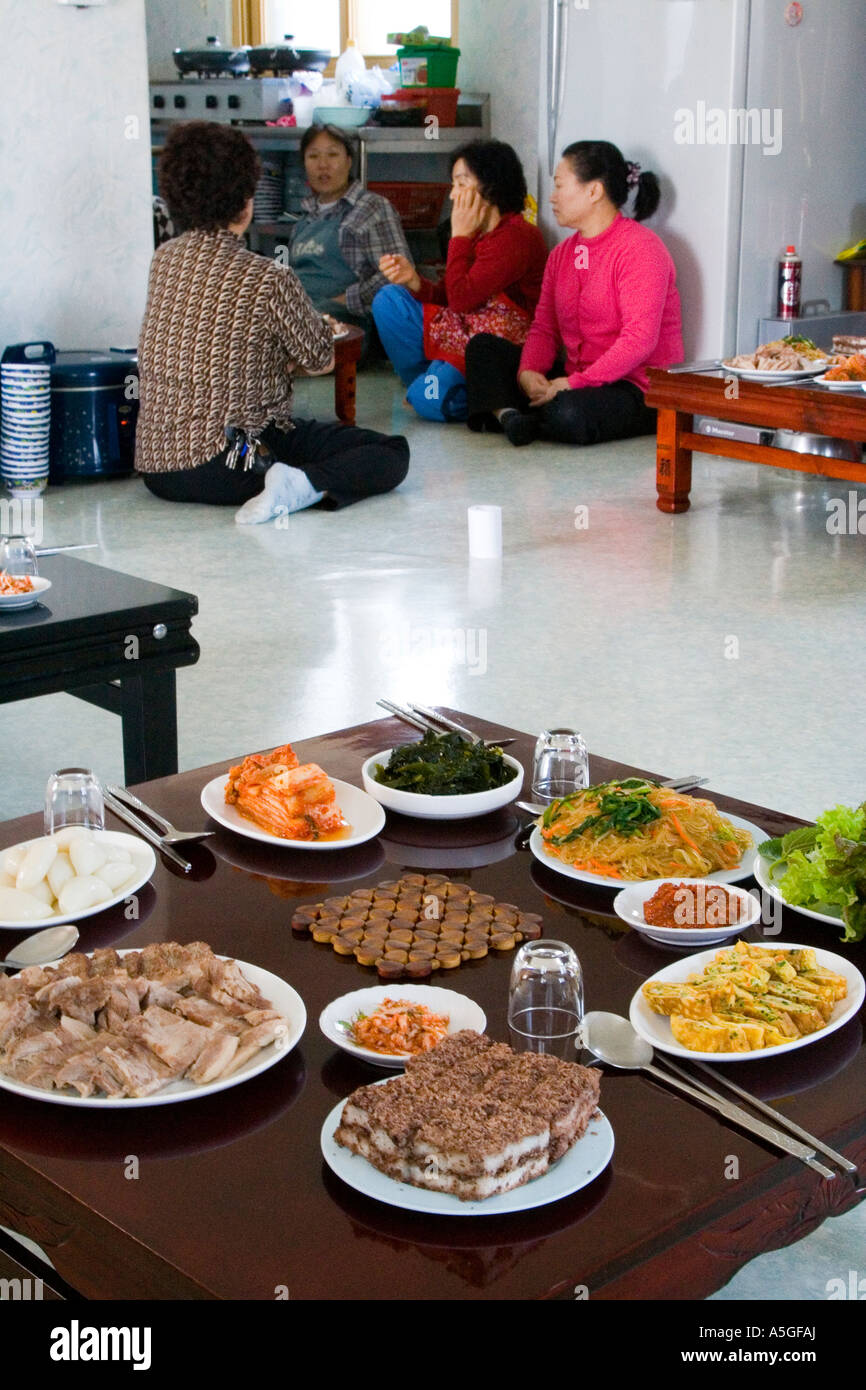 Enti locali le donne coreane dietro un pasto hanno preparato per gli uomini Corea rurale nei pressi di Sokcho, Corea del Sud Foto Stock