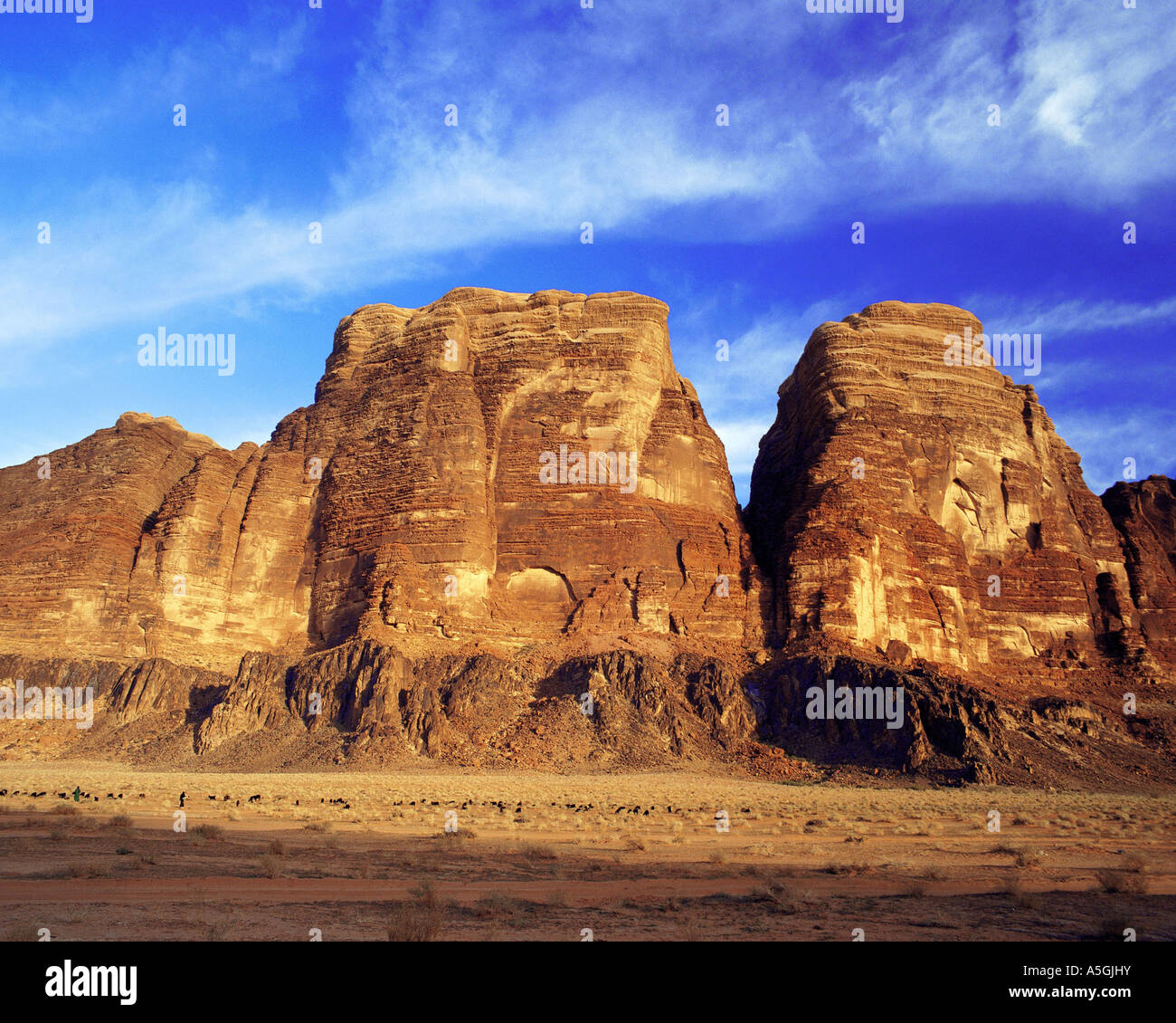 Montagne di arenaria di Wadi Rum, con pastore e gregge in primo piano, Giordania Foto Stock