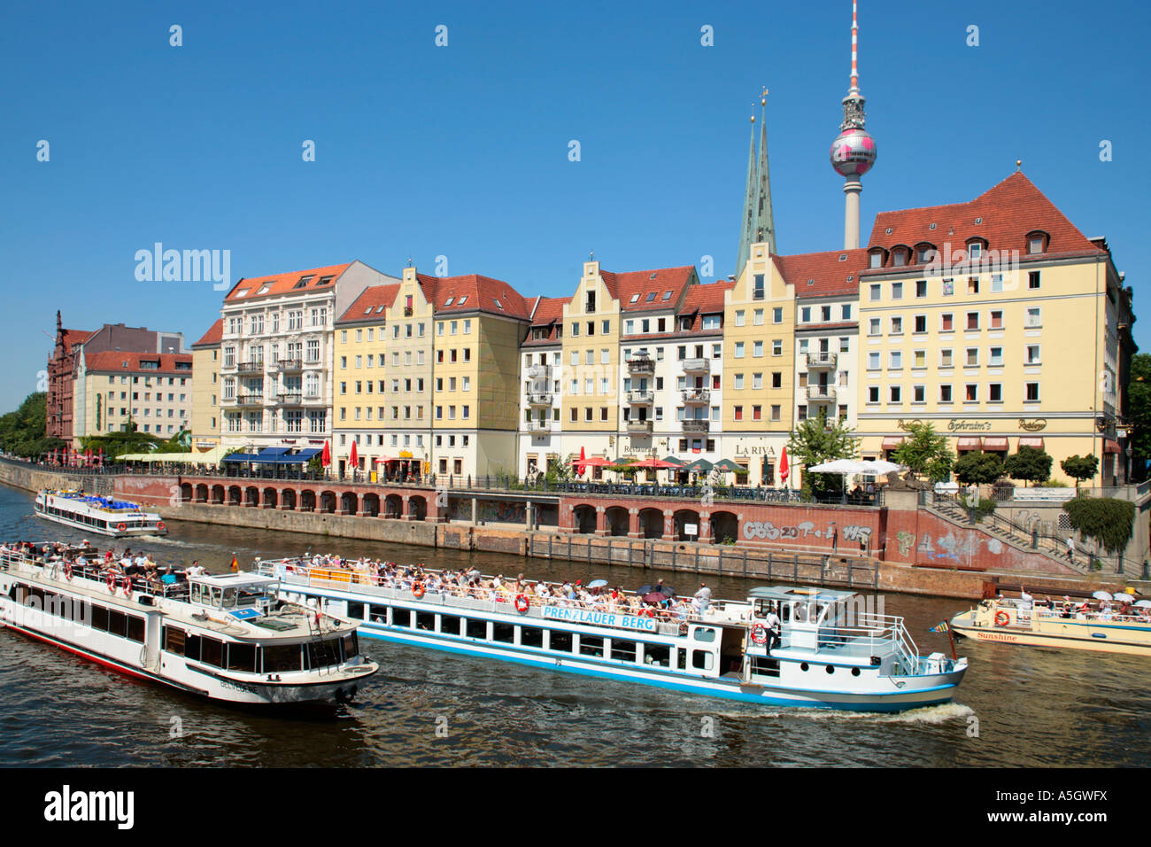 Tour guida di barche sul fiume Sprea a Berlino con la torre della televisione in background Foto Stock