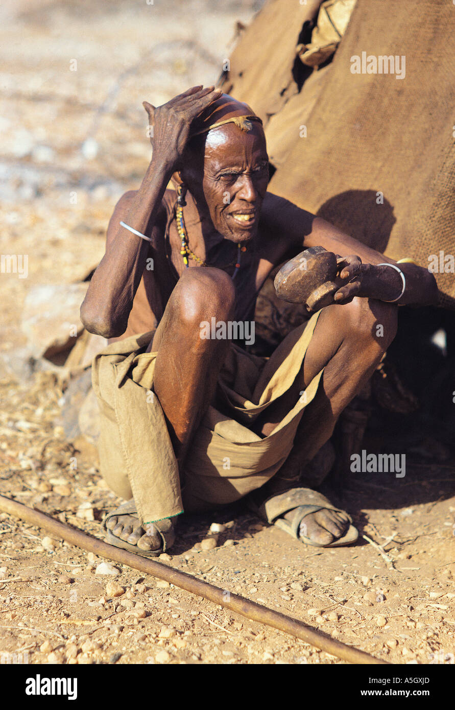 Il vecchio uomo Rendille unzione di sé con il ghee durante la cerimonia SORIU Kenya Africa orientale Foto Stock