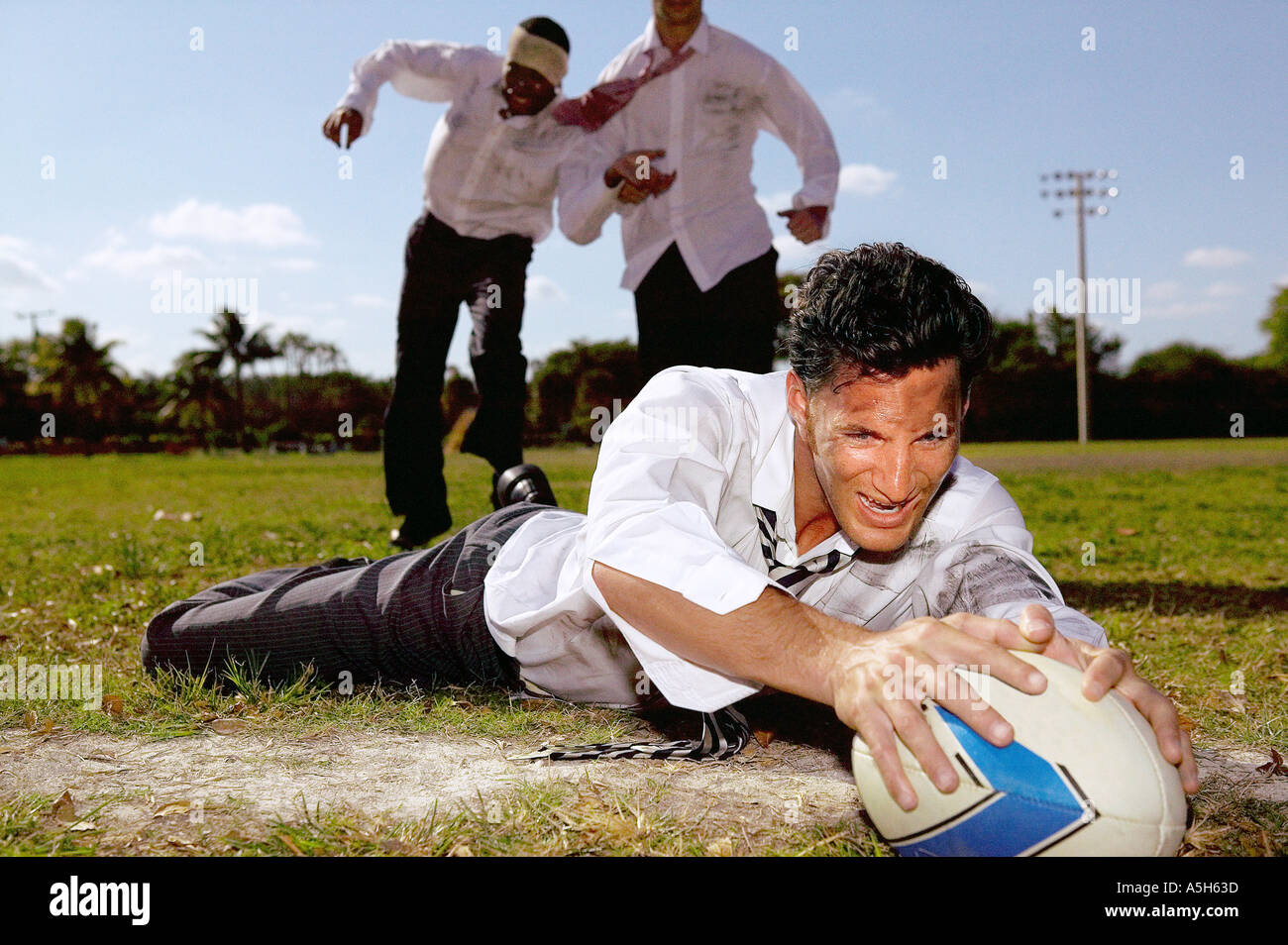 Uomini d'affari giocando a rugby Foto Stock
