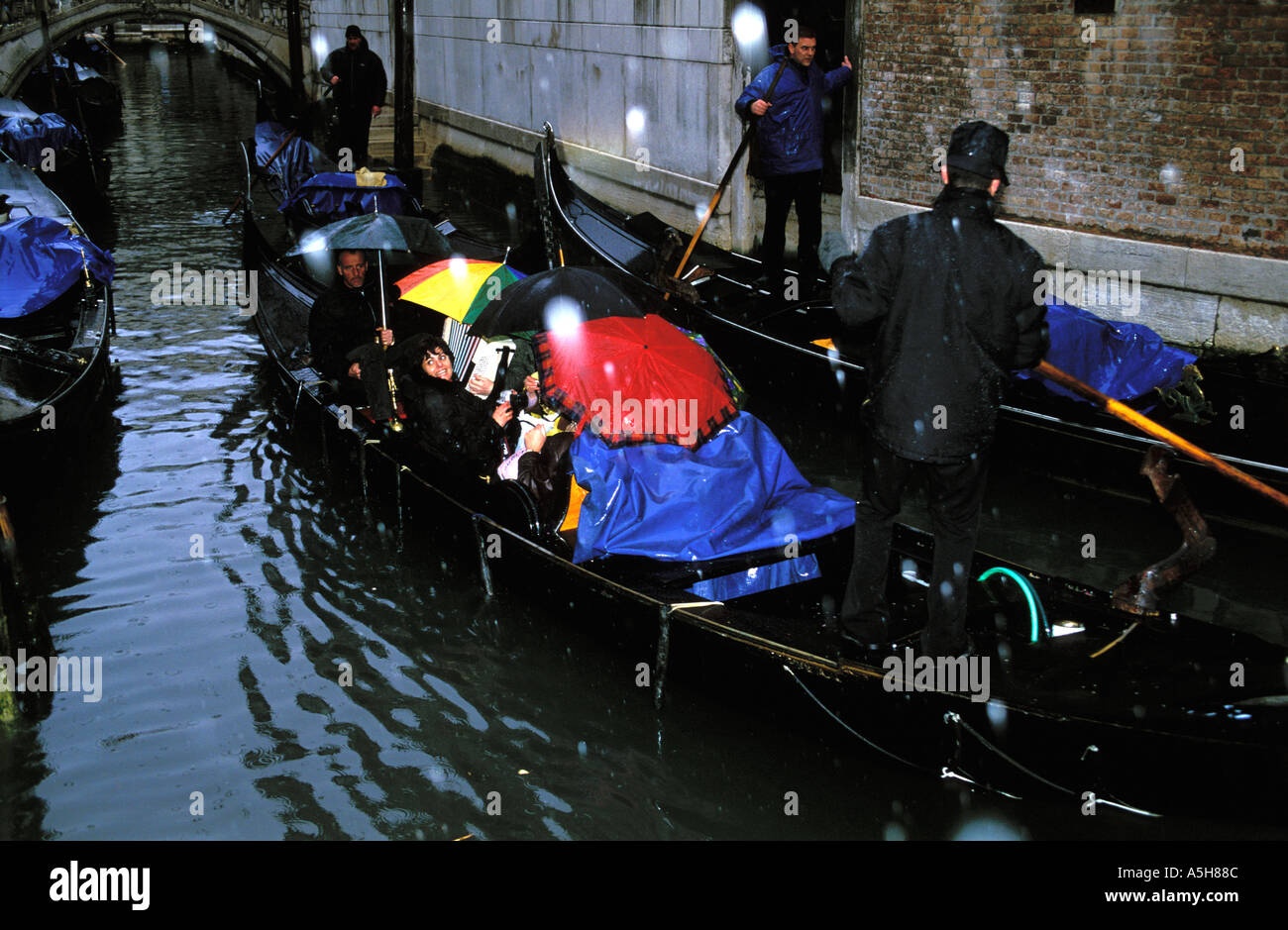 Gondola con tourist passando attraverso canali di Venezia in nevicata Venezia Italia Foto Stock