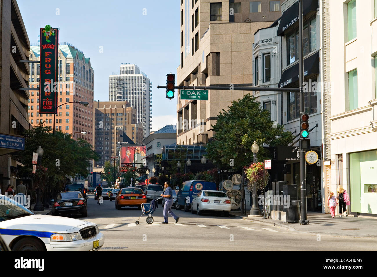ILLINOIS Chicago maschio lavoratore postale spingere il carrello in crosswalk Rush Street e Oak Street intersezione Gold Coast e al quartiere per lo shopping Foto Stock