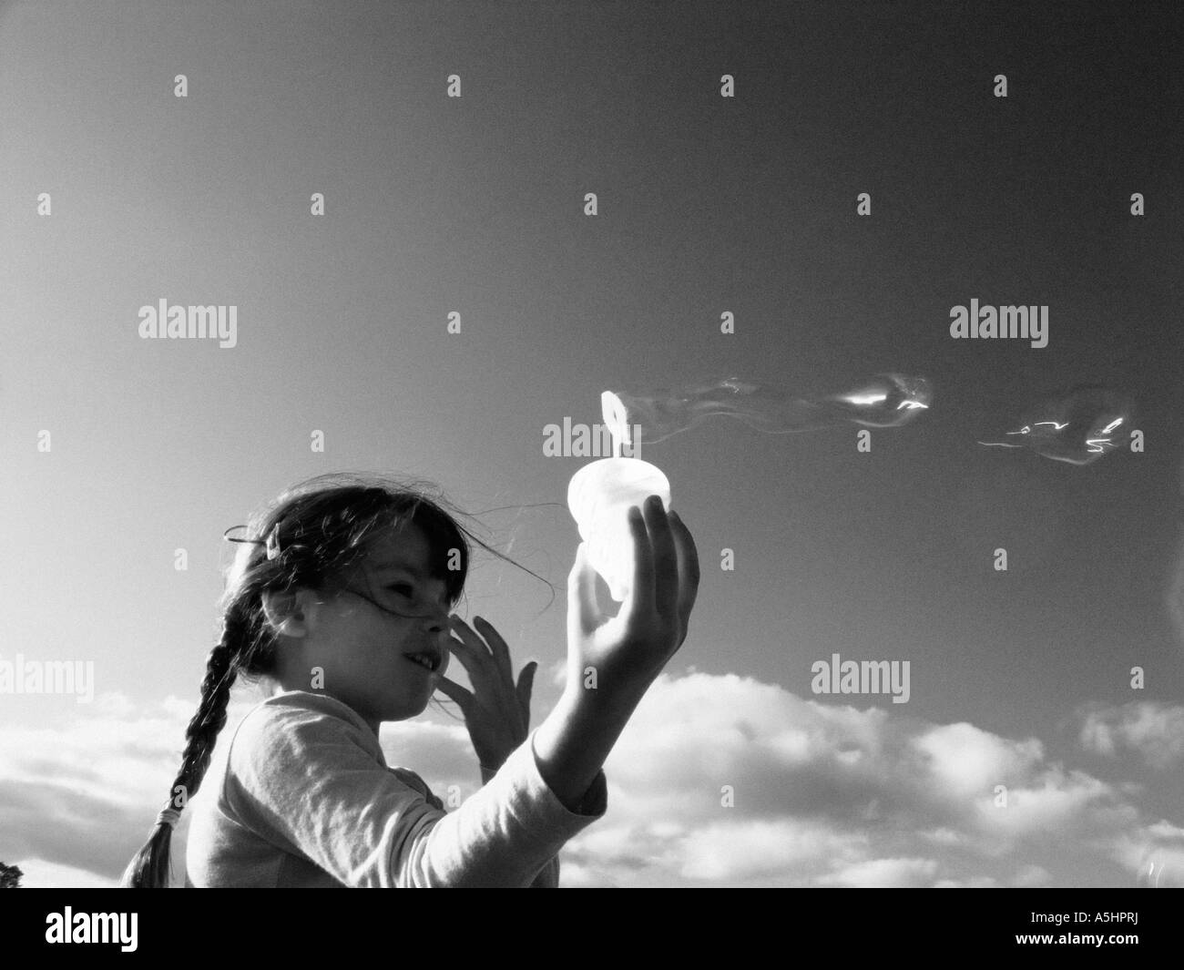 Bambina gioca con le bolle di sapone nel parco Foto Stock