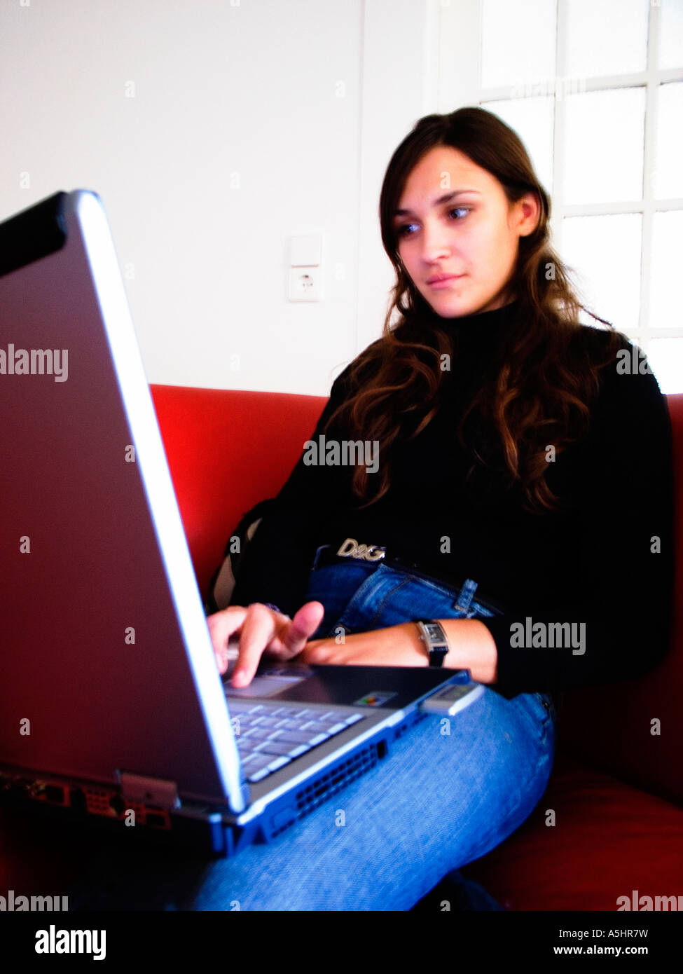 Giovane donna su un portatile a casa Foto Stock