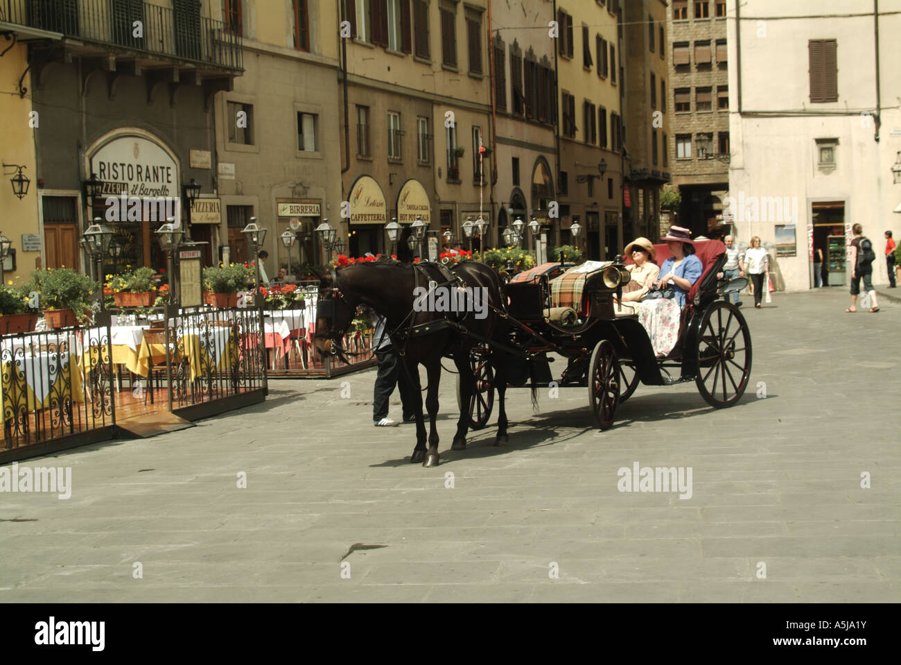 Italiano di cavallo e aprire il trasporto di due donne che i passeggeri in arrivo al marciapiede ristoranti & bar in Piazza della Signoria a Firenze Toscana Italia EU Foto Stock