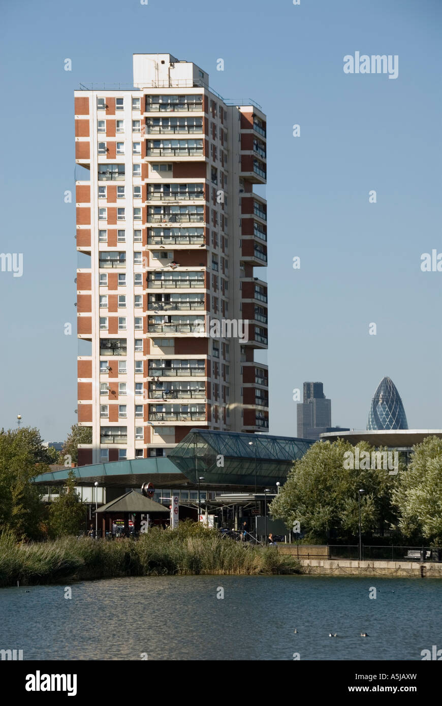 Rotherhithe alto autorità locali complesso residenziale accanto al lago con la City Of London skyline al di là Foto Stock