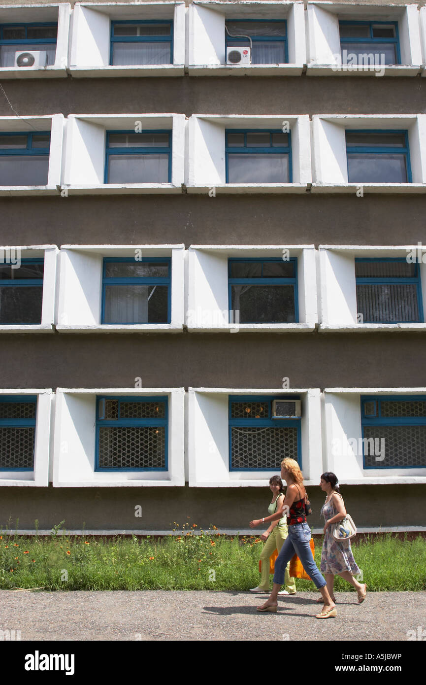 Le donne a piedi passato comunista edificio di stile Foto Stock