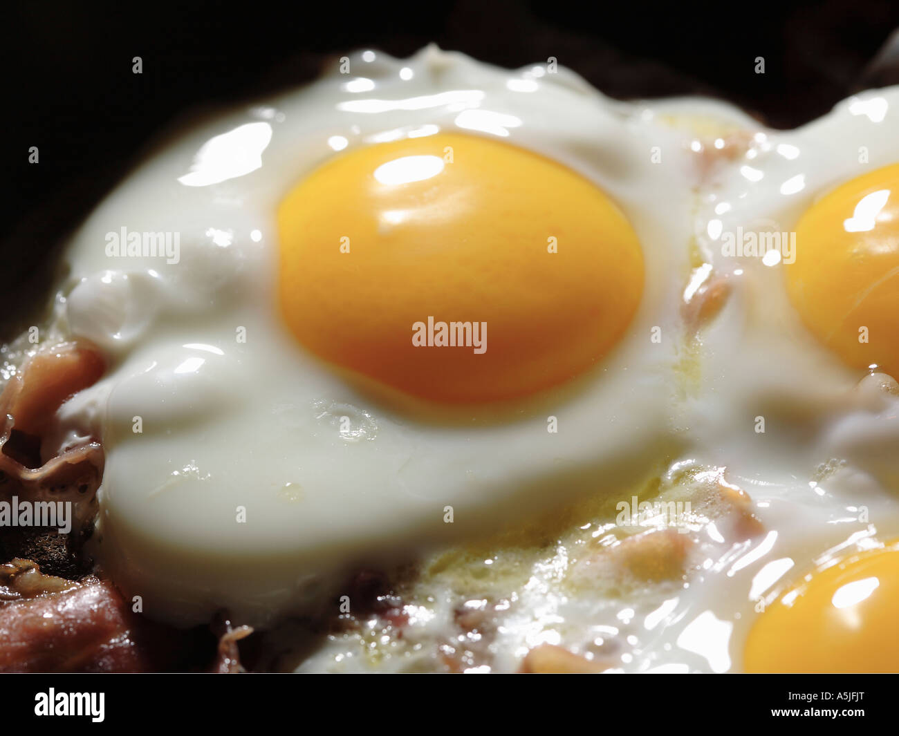 Uovo fritto sunny side up con il bacon in padella calda close up Foto Stock
