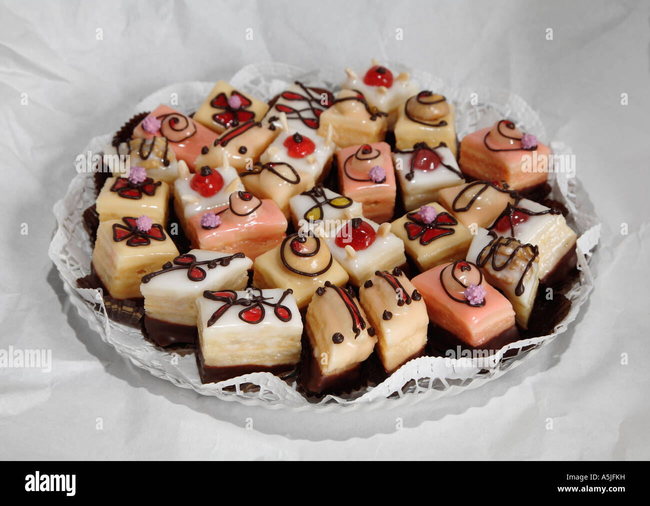 Piastra con petit fours biscotti sulla carta zigrinato Foto Stock