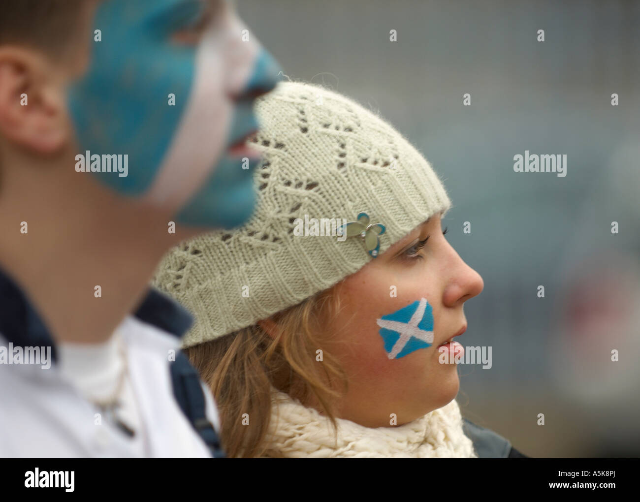 Giovane uomo e donna con bandiere scozzese dipinta sul loro volto Foto Stock