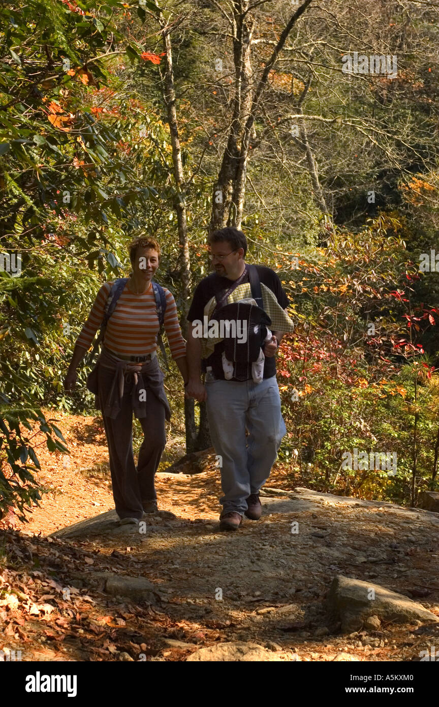 Un paio di passeggiate su un sentiero con il fiume Horsepasture in cassieri area di North Carolina l uomo sta portando il suo nuovo bambino sul suo petto in un baby carrier Foto Stock