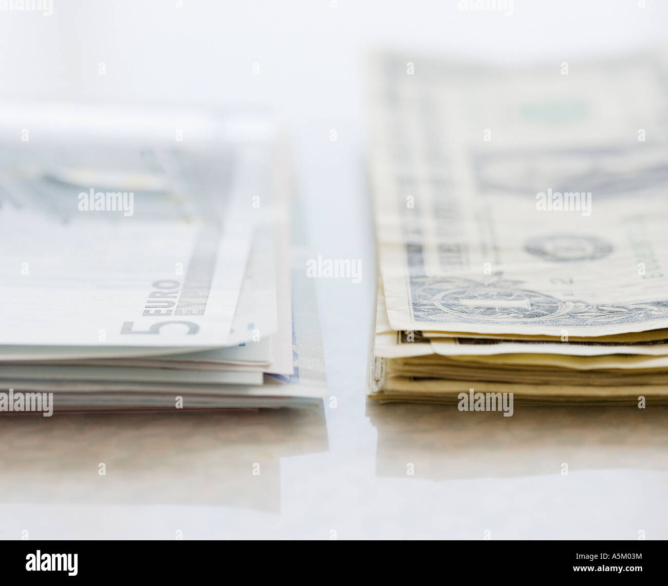 Pile di euro e dollari americani Foto Stock