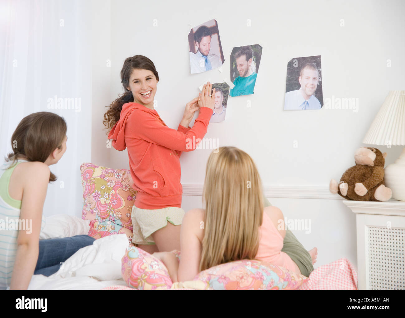 Le ragazze adolescenti rivista appendere le immagini sulla parete Foto Stock