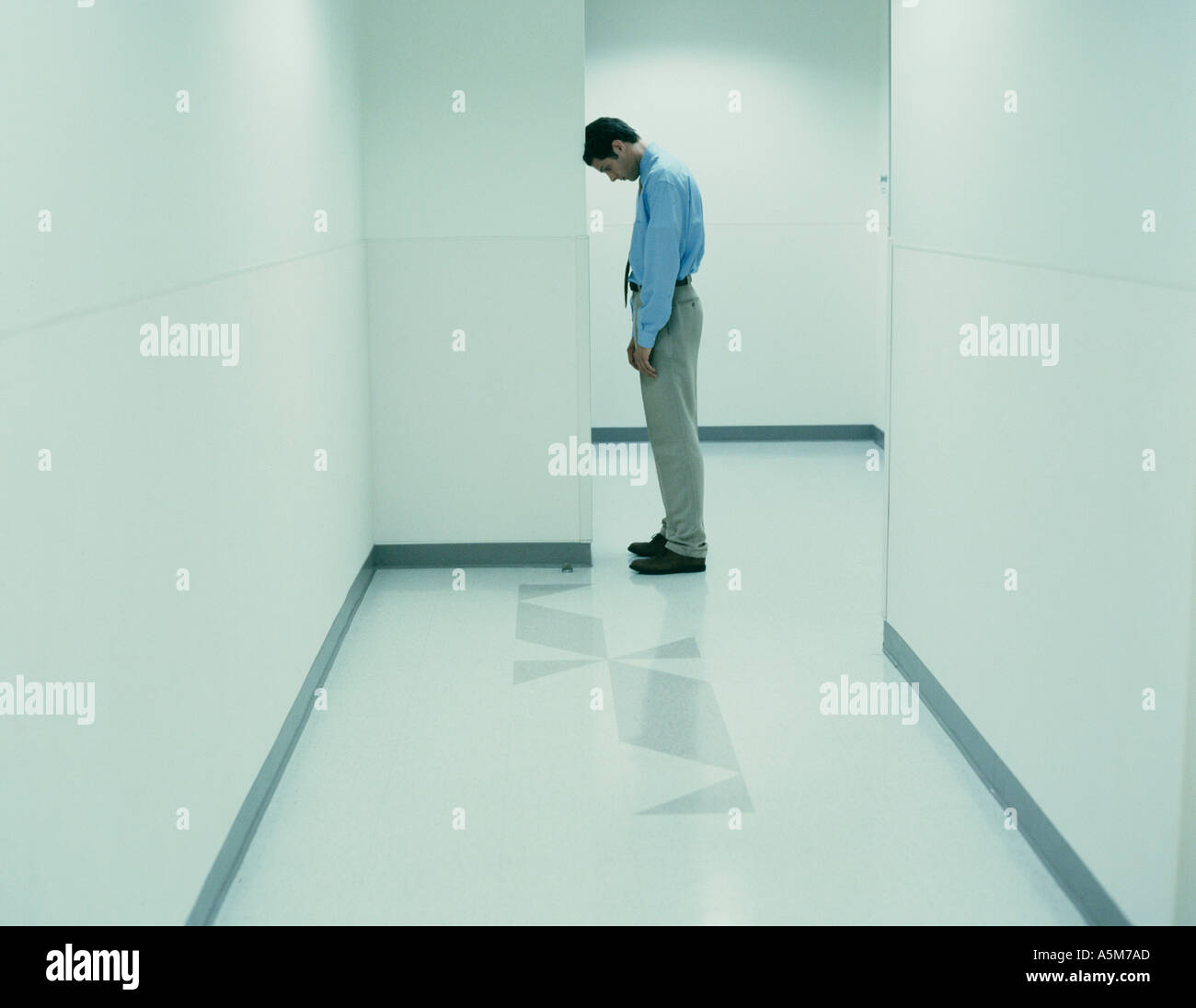 Ufficio aziendale lavoratore appoggia la testa contro il muro di corridoio Foto Stock
