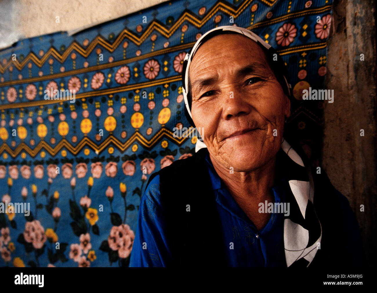 Anziani Uighur nella sua casa sulla Via della Seta, Khotan, Xinjiang, Cina Foto Stock