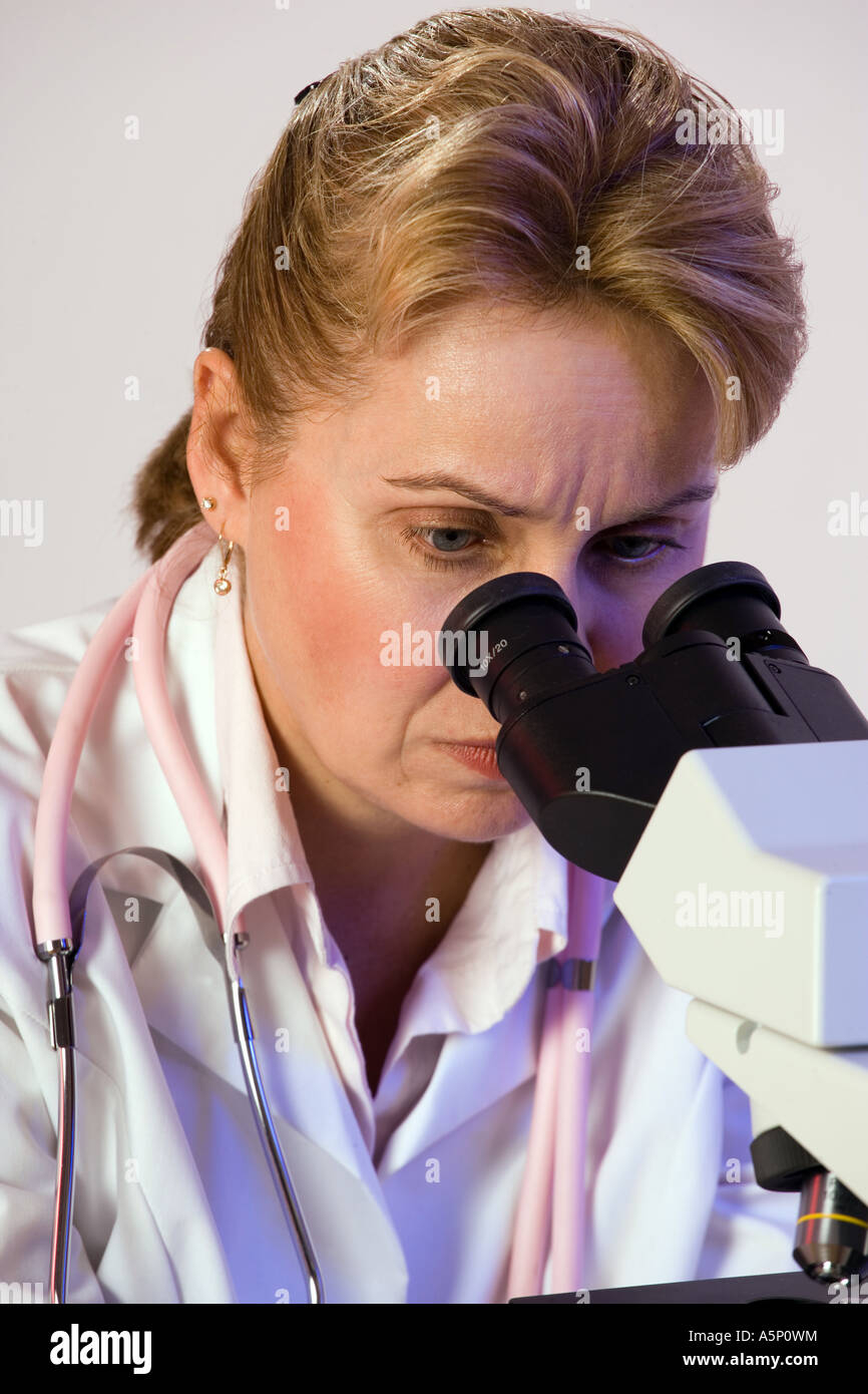 Ricercatore di cancro utilizza il microscopio per visualizzare campione per biopsia. Foto Stock