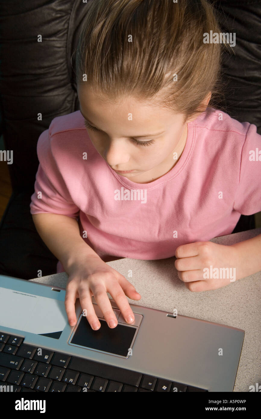 Ragazza giovane facendo il suo compiti mentre si utilizza il suo computer portatile. Foto Stock