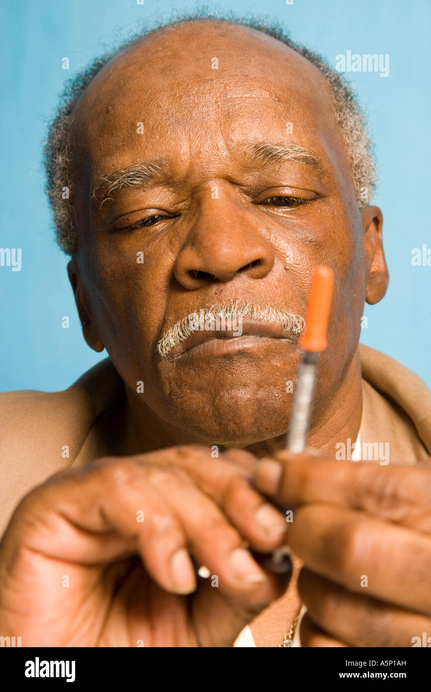 L uomo si prepara un iniezione di insulina come egli tratta con il suo diabete su una base everday. Foto Stock
