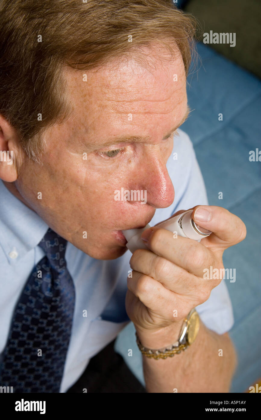 Uomo che utilizza un inalatore durante un attacco asmatico. Foto Stock