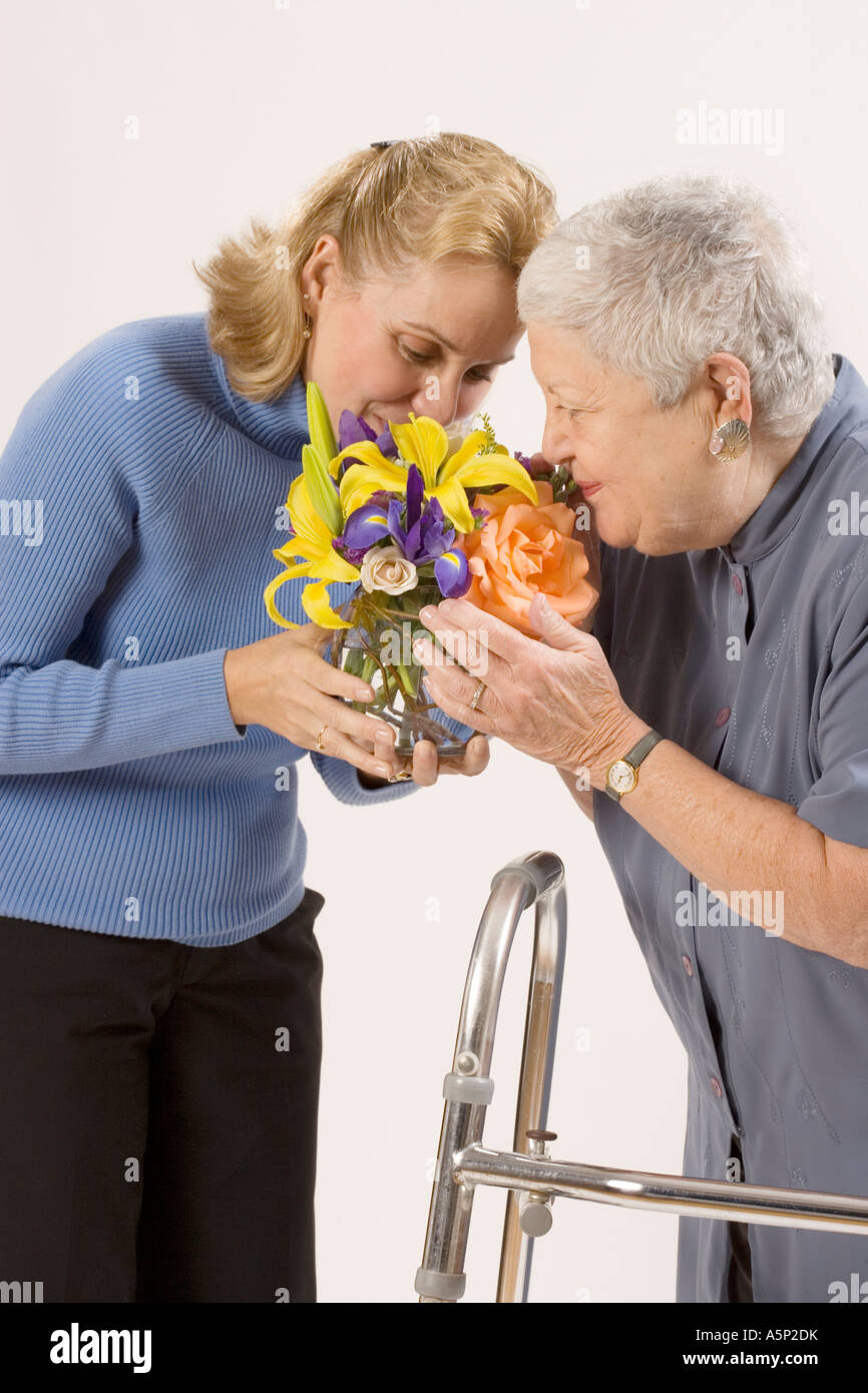 Due donne a sentire il profumo dei fiori. Foto Stock