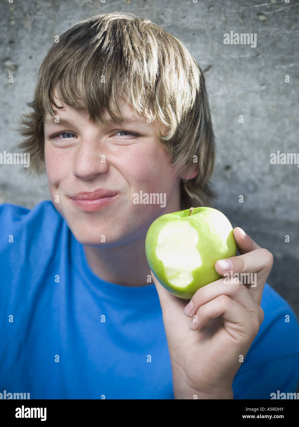 Ritratto di un ragazzo adolescente una mela e sorridente Foto Stock