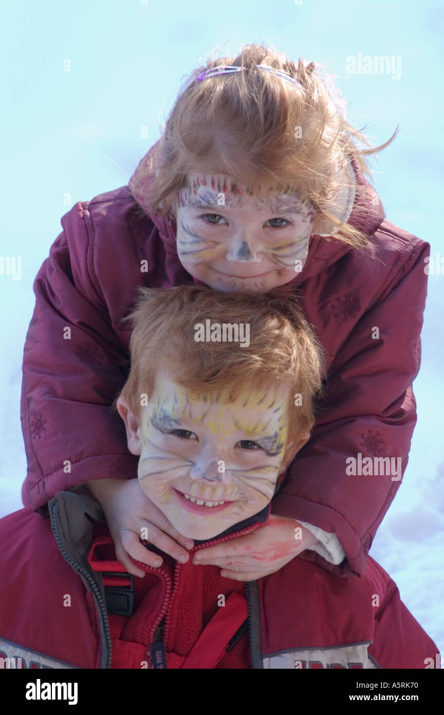 Signor due bambini con facce dipinte come gatti per carnevale Foto Stock