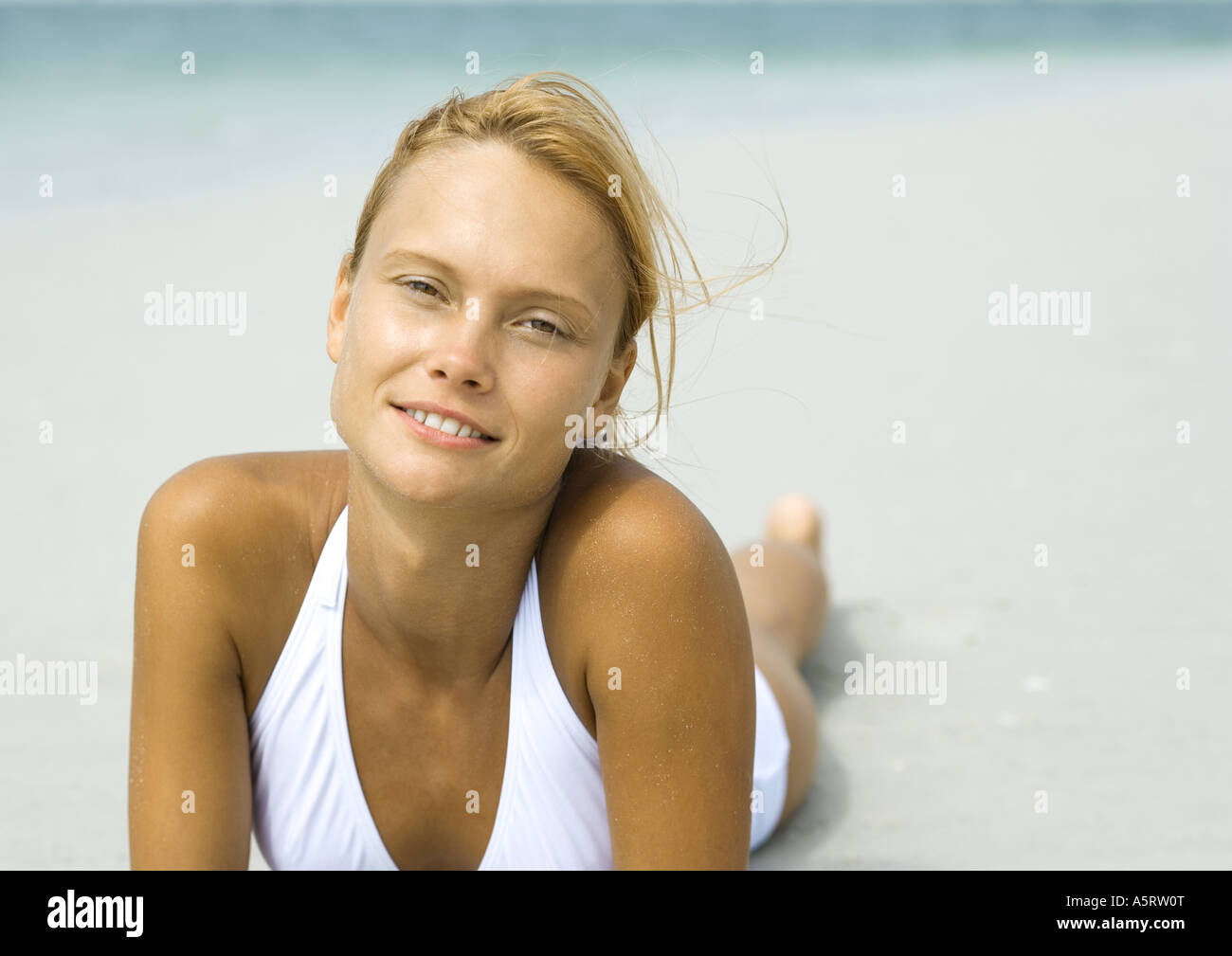 Donna sdraiata sulla spiaggia Foto Stock