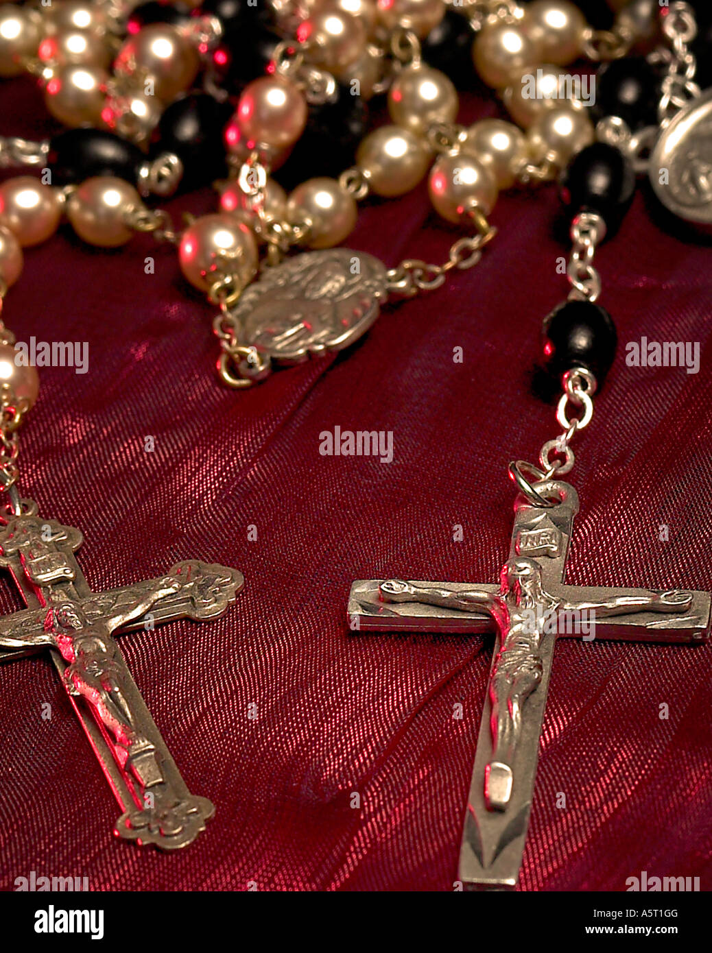 Macro colpo di due rosari su sfondo rosso Foto Stock