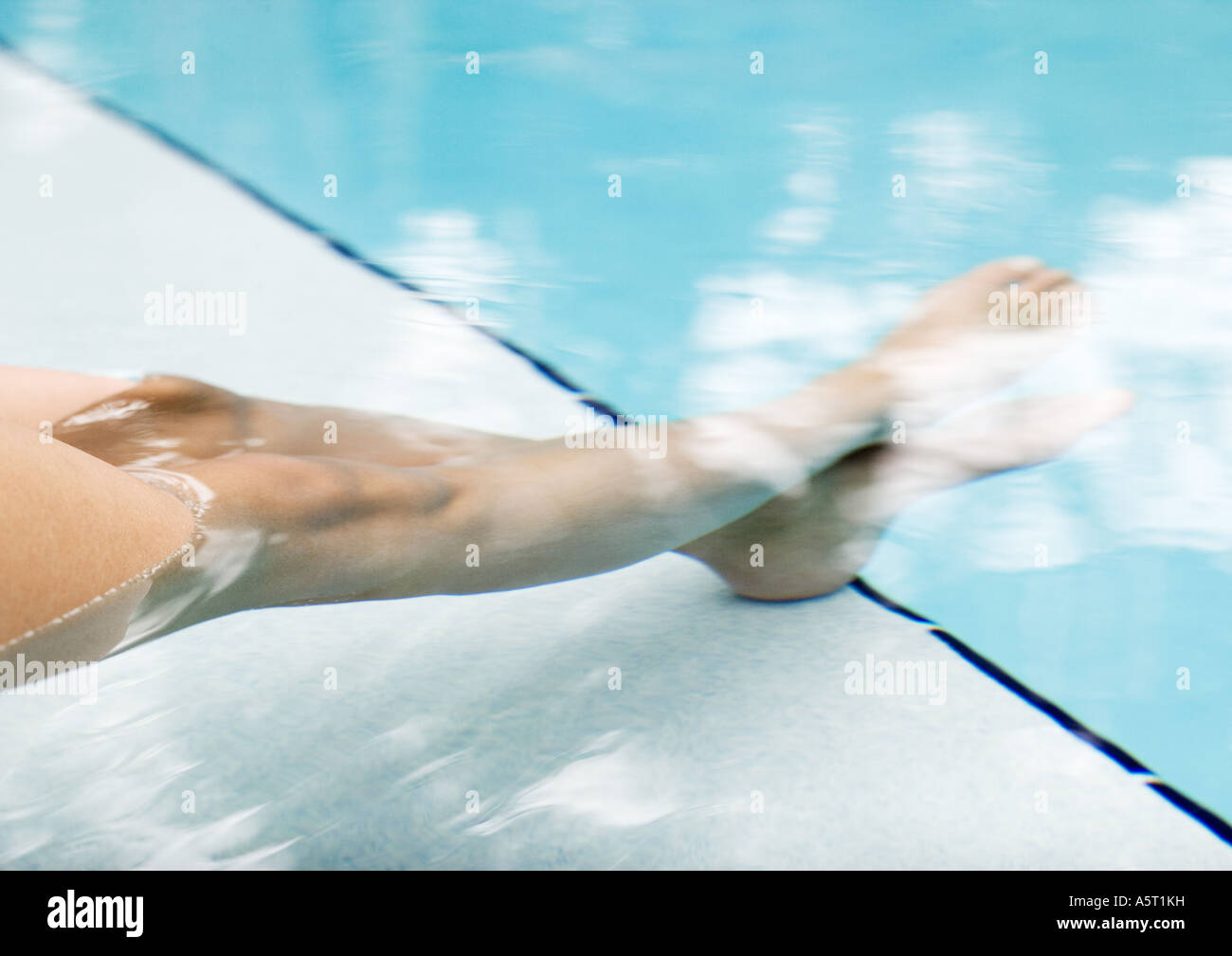 Donna di immergere le gambe in piscina, sezione bassa Foto Stock