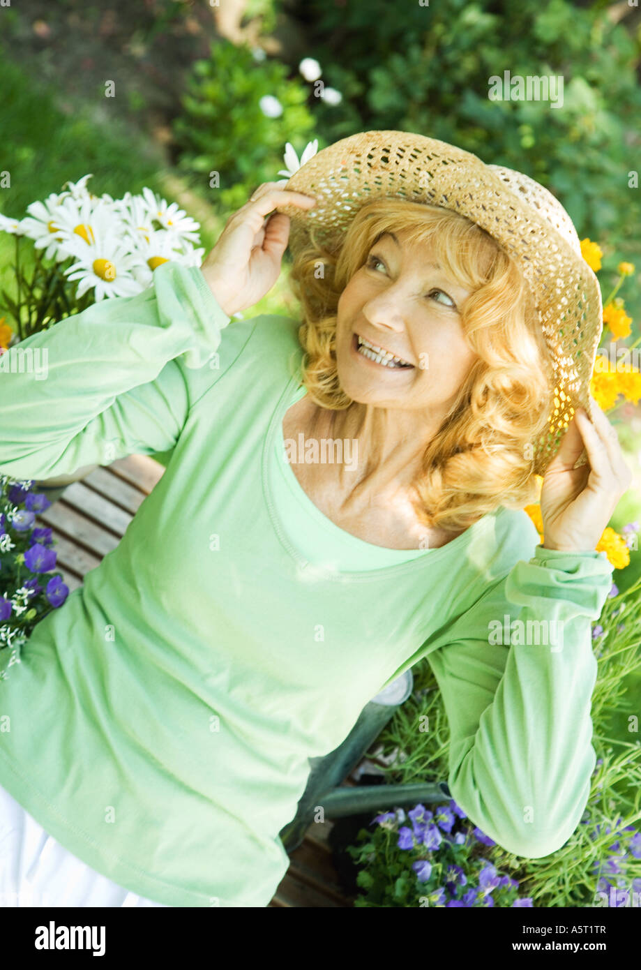 Senior donna che indossa cappello di paglia, ritratto Foto Stock