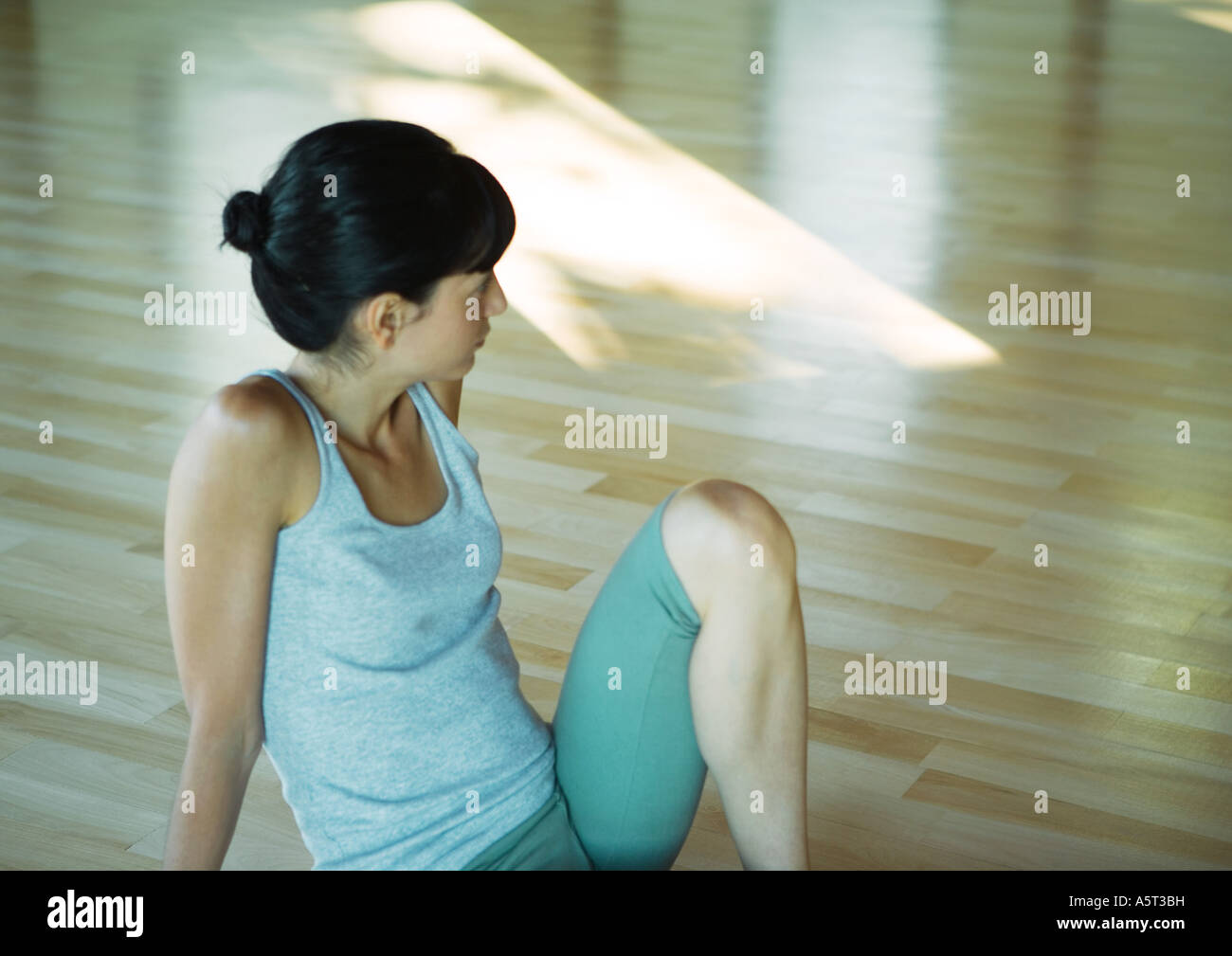 Classe di yoga, donna seduta con il ginocchio in alto Foto Stock