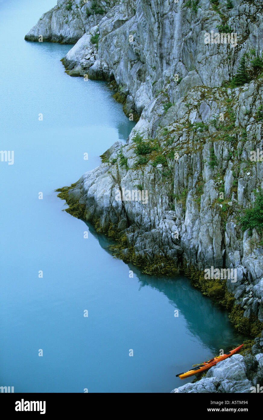 Alaska Kenai fiordi Parco Nazionale di kayak da mare spiaggiata sulla costa rocciosa di un'isola con acqua calma Foto Stock